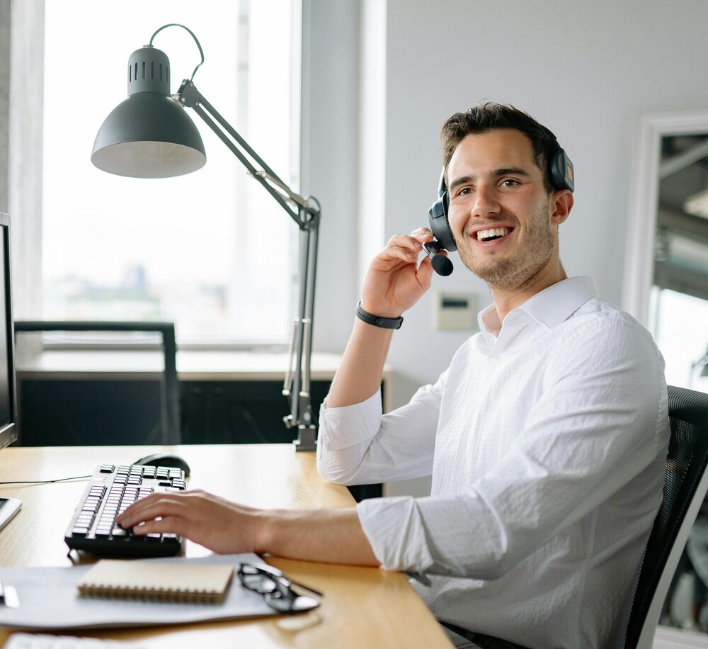 Smiling HR consultant providing individual support via headset in a modern office setting
